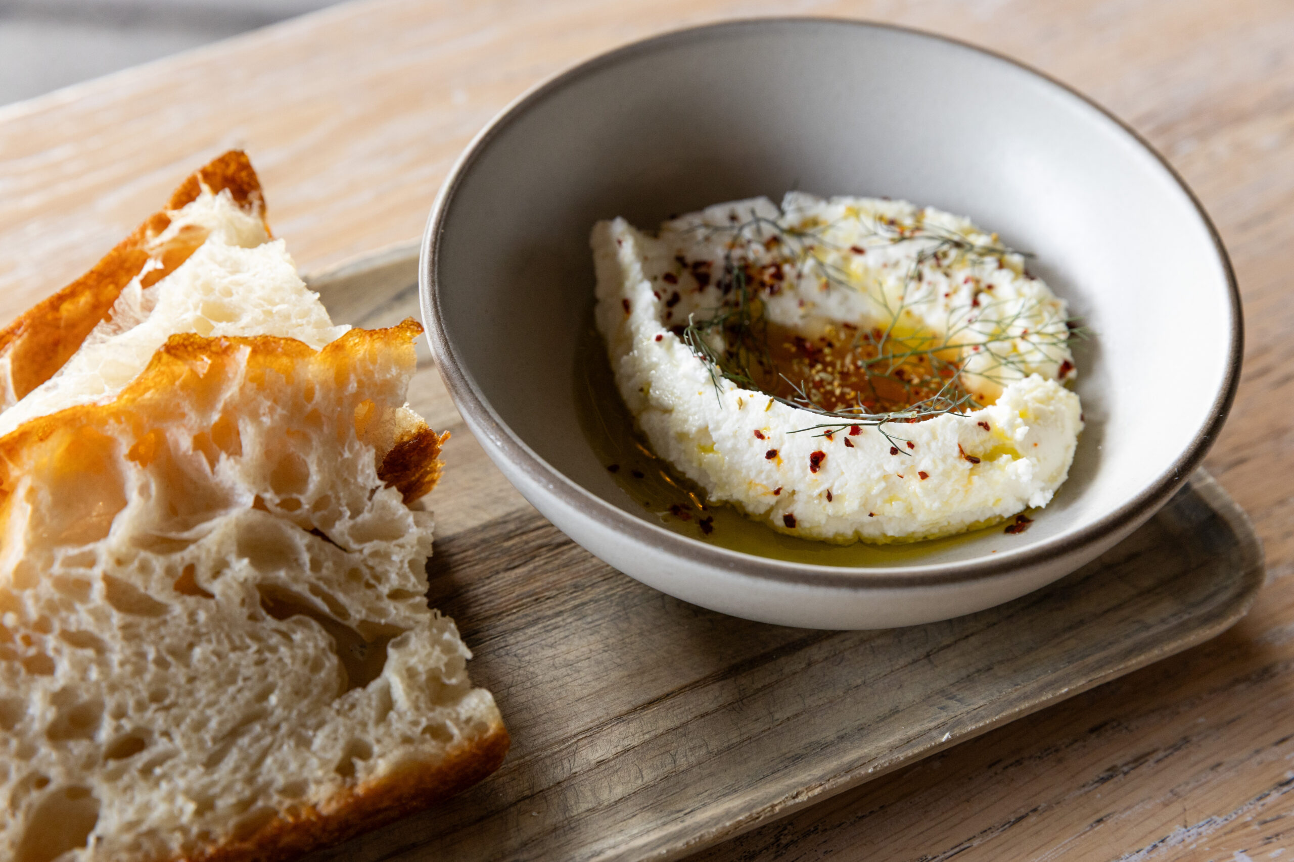 A photo of bread and ricotta dip.