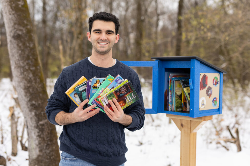 Jack Furman is photographed with a Little Free Library.